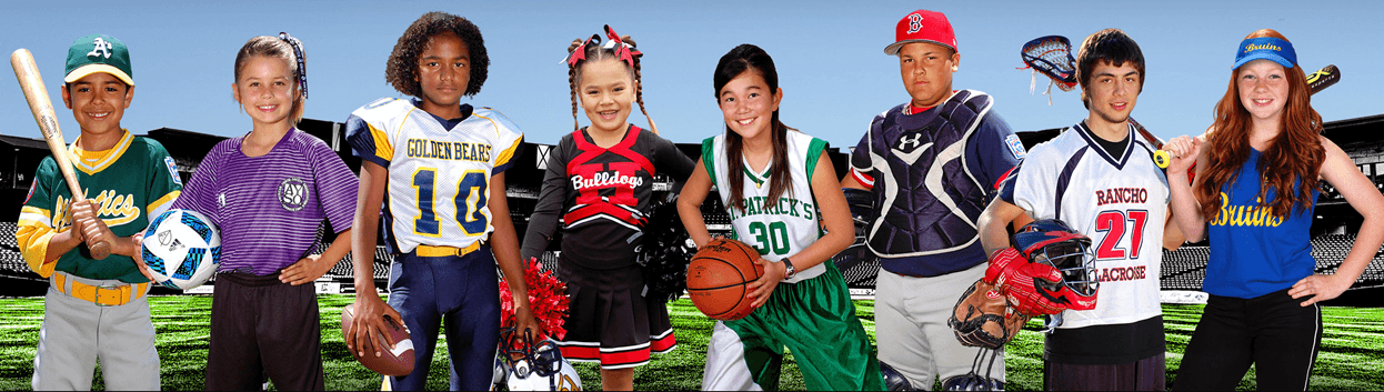 Diverse group of young athletes in various sports uniforms posing with equipment in a stadium.